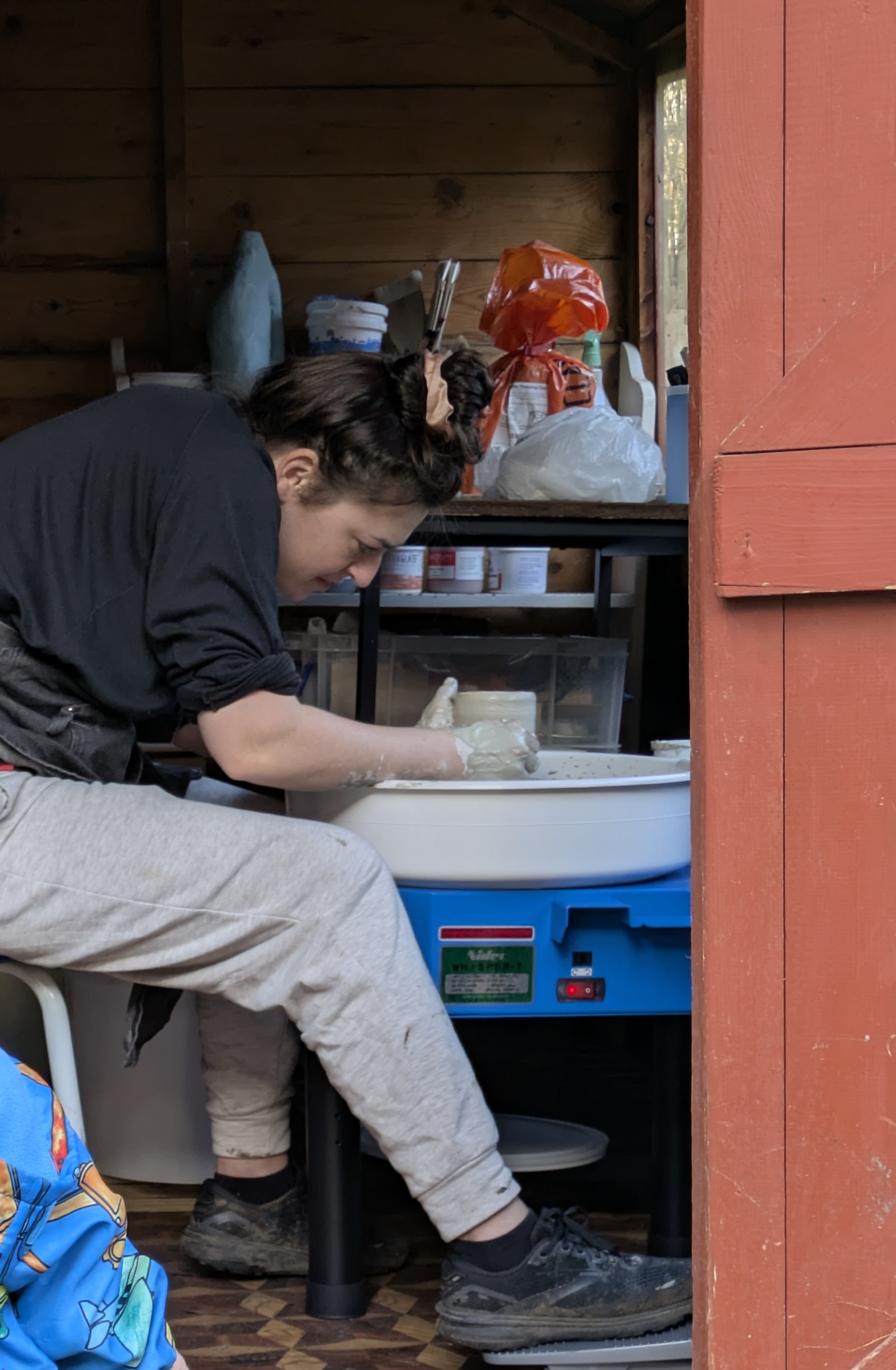 The ceramicist shaping clay at the pottery wheel